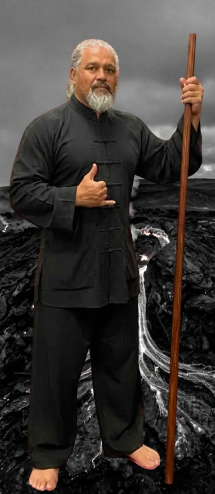 Sifu Thomas Hulama, Iron Kingz Wing Chun instructor, holding a long pole on a black lava field