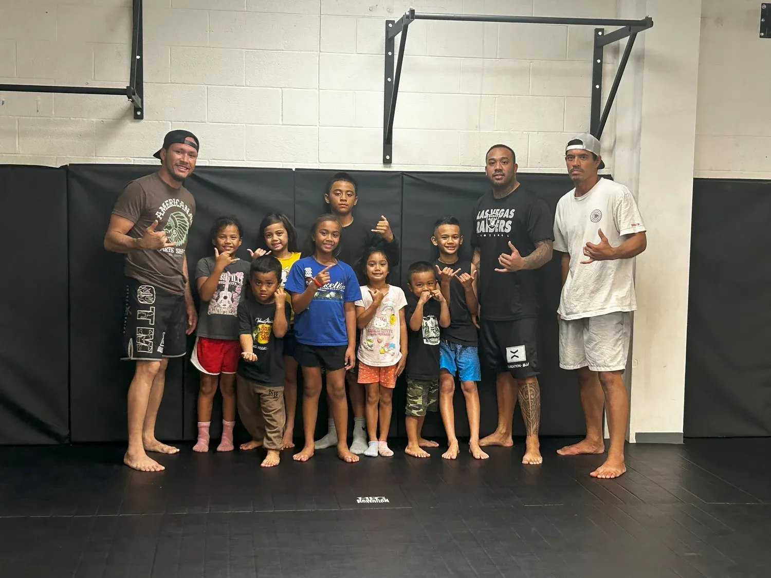Iron Kingz coaches and keiki holding trophies after a competition